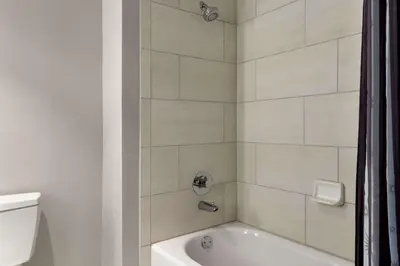 a bathroom with a white tub and a toilet at La Quinta Inn & Suites by Wyndham Orlando I-Drive Theme Parks in Orlando