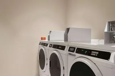a white washing machine with two boxes on top of it at La Quinta Inn & Suites by Wyndham Orlando I-Drive Theme Parks in Orlando