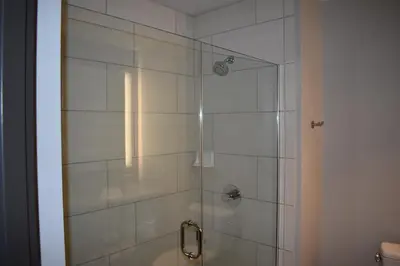 a bathroom with a shower with a glass door at La Quinta Inn & Suites by Wyndham Orlando I-Drive Theme Parks in Orlando