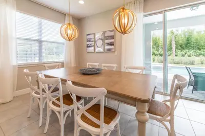 a dining room with a wooden table and chairs at Precious Home Near Disney With Private Pool, Theater Room And Waterpark & Resort Access At Encore Resort Reunion - 7449Mr in Kissimmee
