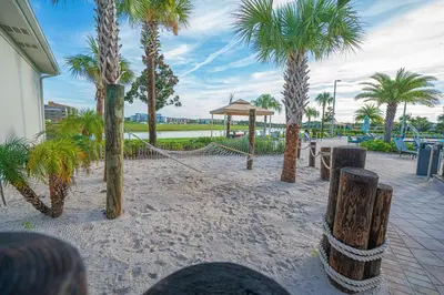 a sandy area with palm trees and a pavilion at Only 5 Miles from Disney! Free Water Park! 2 Bed, 2 Bath Condo, Sleeps 8 in Kissimmee