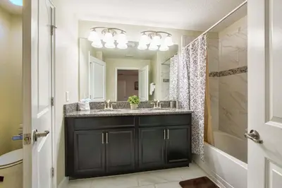 a bathroom with a black vanity and a shower at I - New 4 Bedroom Home - 5 Miles to Disney - Free Water Park - Private Pool in Kissimmee