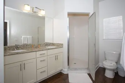 a white bathroom with a toilet and a sink at 2956 Lucaya Village - Gorgeous Four Bed Condo Close to Disney Area in Kissimmee