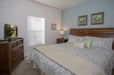 a bedroom with a bed with a television and a dresser at 2956 Lucaya Village - Gorgeous Four Bed Condo Close to Disney Area in Kissimmee