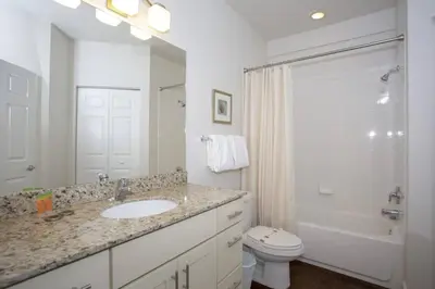 a white bathroom with a sink and a toilet at 2956 Lucaya Village - Gorgeous Four Bed Condo Close to Disney Area in Kissimmee
