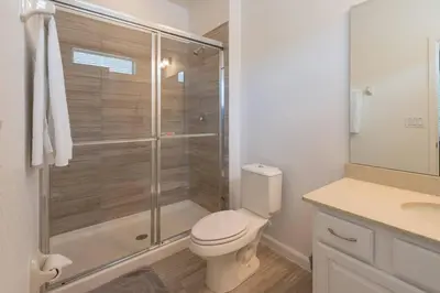 a bathroom with a toilet and a glass shower at 3840 Supreme Villa 6Bd Private Pool and Game Room in Kissimmee