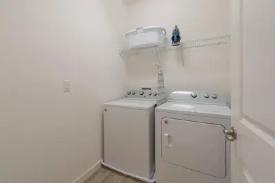 a white laundry room with a washer and dryer at 3840 Supreme Villa 6Bd Private Pool and Game Room in Kissimmee