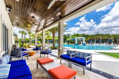 a patio with blue chairs and a swimming pool at 3840 Supreme Villa 6Bd Private Pool and Game Room in Kissimmee