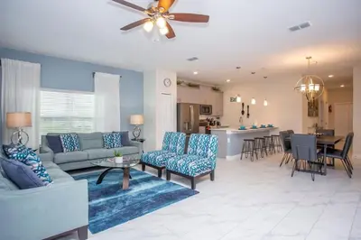 a living room with a couch and chairs and a kitchen at Wonderful 5 Bedroom w/ Pool Close to Disney 4801 in Kissimmee