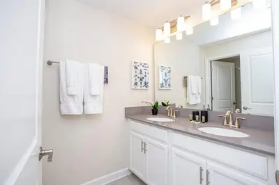 a white bathroom with two sinks and a mirror at Gorgeous 4 Bedroom w/ Pool Close to Disney 4836 in Kissimmee