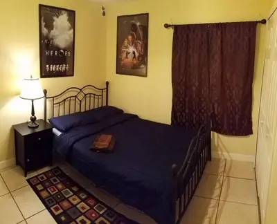 a bedroom with a bed with a blue comforter at B2 Private Room With 55