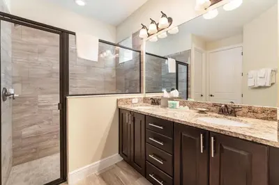 a bathroom with two sinks and a shower at Elegant Home Near Disney With Private Pool And Waterpark & Resort Access At Encore Resorts Reunion - 430La in Kissimmee