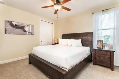 a bedroom with a large bed and a ceiling fan at Elegant Home Near Disney With Private Pool And Waterpark & Resort Access At Encore Resorts Reunion - 430La in Kissimmee