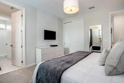 a white bedroom with a large bed and a television at Jedi Temple! Take A Virtual Tour Private Pool! Villa in Orlando