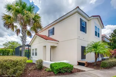 a white house with palm trees in front of it at Bella Vidatown Home With Full Size Pool! Townhouse in Kissimmee