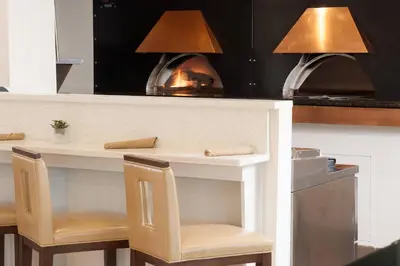 a kitchen with a counter with chairs and a fireplace at Delta Hotels by Marriott Orlando Lake Buena Vista in Orlando
