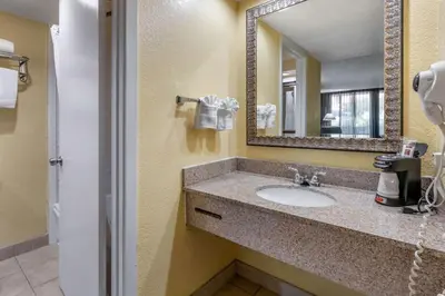 a bathroom with a sink and a mirror at Clarion Inn Orlando International Drive - ICON Park in Orlando