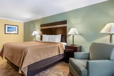a hotel room with a bed and a chair at Clarion Inn Orlando International Drive - ICON Park in Orlando