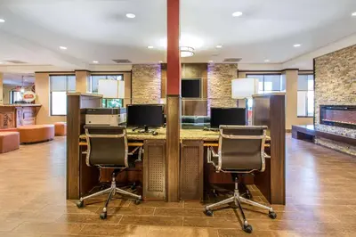 a lobby with a desk with three chairs in a room at The Adventure Hotel by the Parks in Orlando