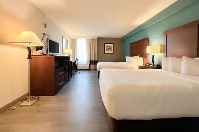 a hotel room with two beds and a television at The Adventure Hotel by the Parks in Orlando