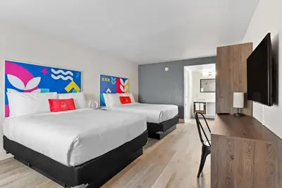 a hotel room with two beds and a flat screen tv at Howard Johnson by Wyndham Orlando Lake Buena Vista South in Kissimmee