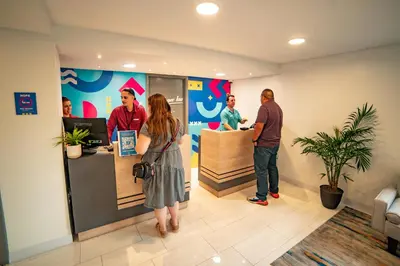 a group of people standing at a counter in a store at Howard Johnson by Wyndham Orlando Lake Buena Vista South in Kissimmee