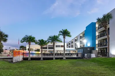 a large apartment building with palm trees in a park at Hotel Monreale Express International Drive Orlando in Orlando