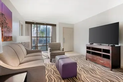 a living room with a couch and a tv at Parkway International Resort in Orlando