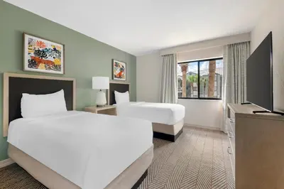 a hotel room with two beds and a flat screen tv at Parkway International Resort in Orlando