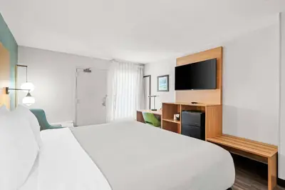 a hotel room with a white bed and a television at Quality Inn Orlando Near International Drive in Orlando