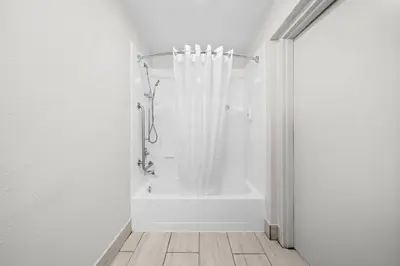 a white bathroom with a tub and a shower at Quality Inn Orlando Near International Drive in Orlando