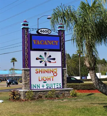 a sign for aatown shifting light inn and suites at Shining Light Inn & Suites in Kissimmee