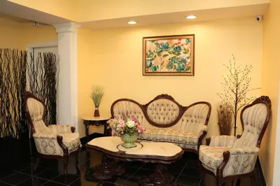 a waiting room with a couch and two chairs at Shining Light Inn & Suites in Kissimmee