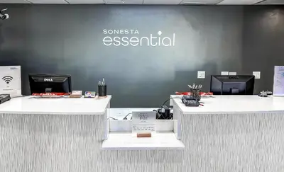 a company office with two reception desks in front of a wall at Sonesta Essential Orlando Airport in Orlando
