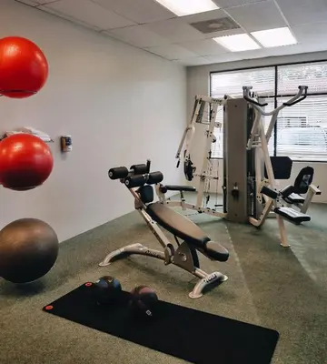 a room with a gym with a treadmill and weights at Parc Corniche Condominium Suites in Orlando