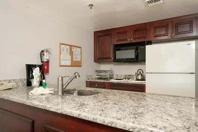 a kitchen with a sink and a white refrigerator at Parc Corniche Condominium Suites in Orlando