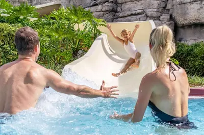 a man and woman playing on a slide at a water park at Caribe Royale Orlando in Orlando