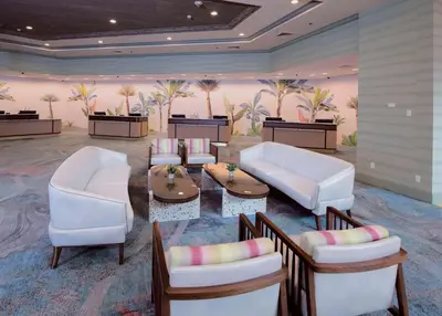 a lobby with white chairs and tables and palm trees at Caribe Royale Orlando in Orlando