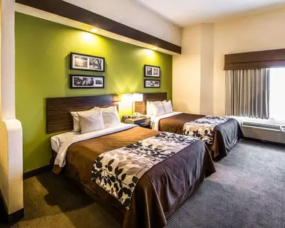 two beds in a hotel room with green walls at Sleep Inn & Suites Orlando International Airport in Orlando