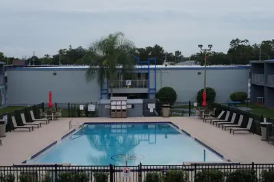 a large swimming pool with chairs and a building at Celebration Suites in Orlando