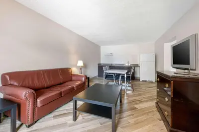 a living room with a couch and a tv and a table at Clarion Inn & Suites Kissimmee-Lake Buena Vista South in Kissimmee