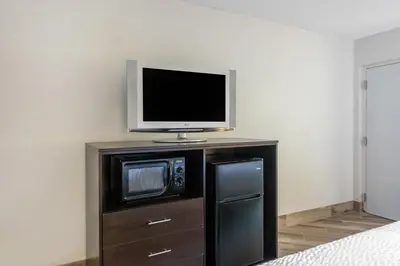 a tv sitting on top of a cabinet with a microwave at Clarion Inn & Suites Kissimmee-Lake Buena Vista South in Kissimmee