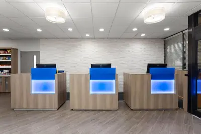 a lobby with blue chairs in an office at Days Inn by Wyndham Orlando Conv. Center/International Dr in Orlando