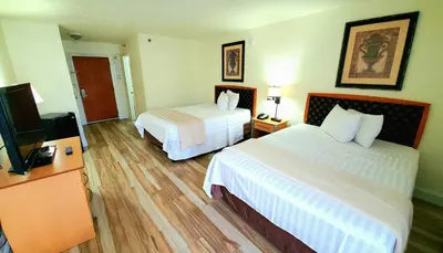 a hotel room with two beds and a flat screen tv at Monumental Movieland Hotel in Orlando