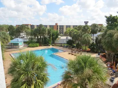 an overhead view of a swimming pool with palm trees at Monumental Movieland Hotel in Orlando