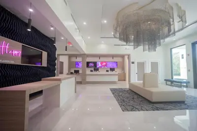 a large lobby with a reception desk and a tv at DASKK Orlando Hotel near Universal Blvd, an Ascend Collection Hotel in Orlando