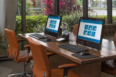a wooden table with two computers on top of it at Four Points by Sheraton Orlando International Drive in Orlando