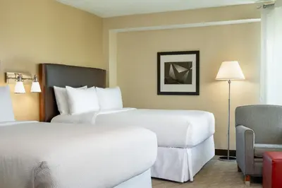 a hotel room with two beds and a chair at Four Points by Sheraton Orlando International Drive in Orlando
