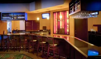 a bar with bar stools in a restaurant at Rosen Inn at Pointe Orlando in Orlando