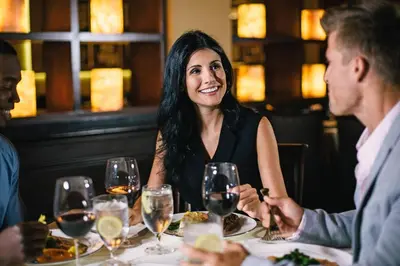 a group of people sitting around a table in a restaurant at Rosen Plaza Hotel Orlando Convention Center in Orlando
